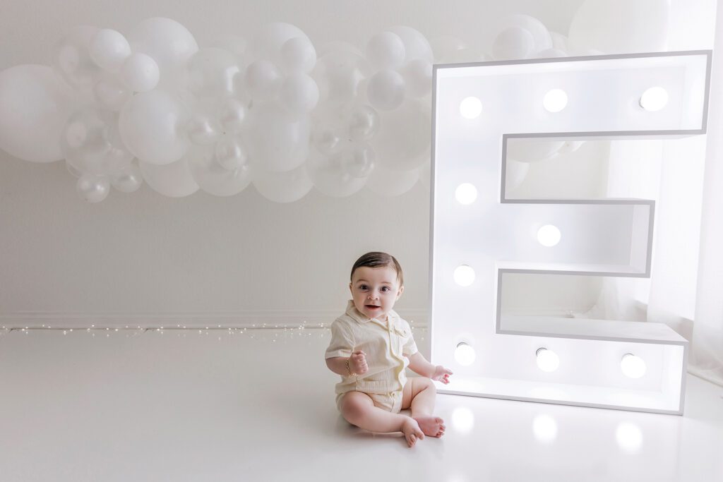 baby with balloon garland