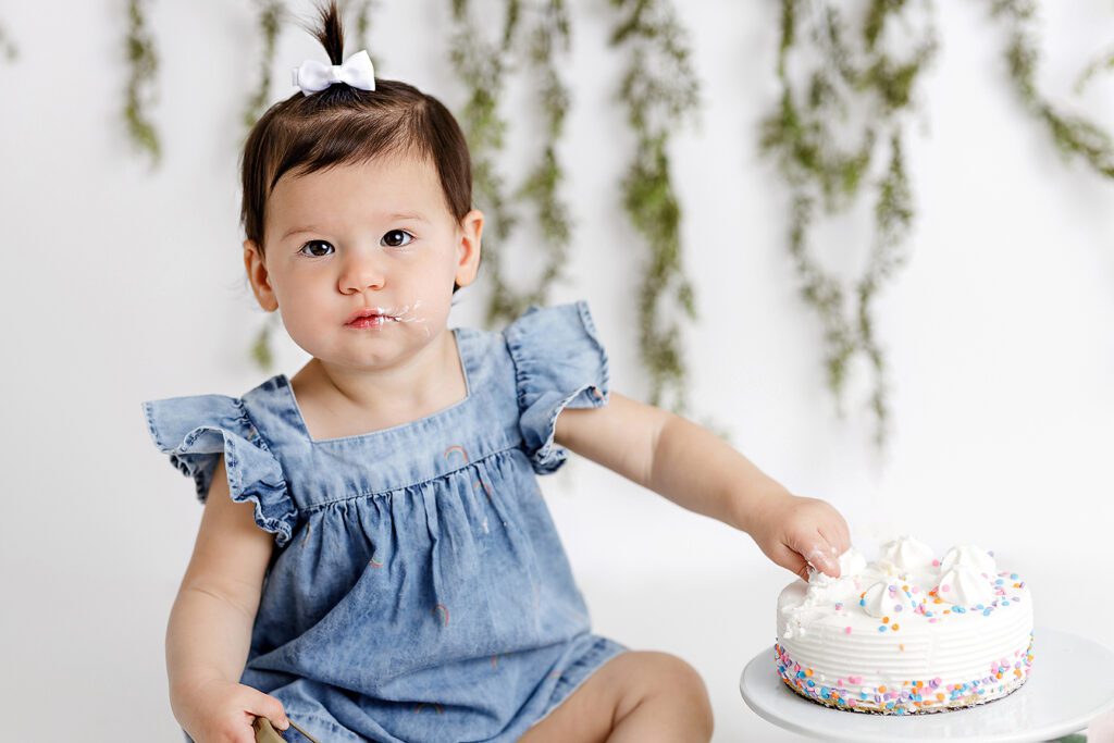 baby girl eating birthday cake