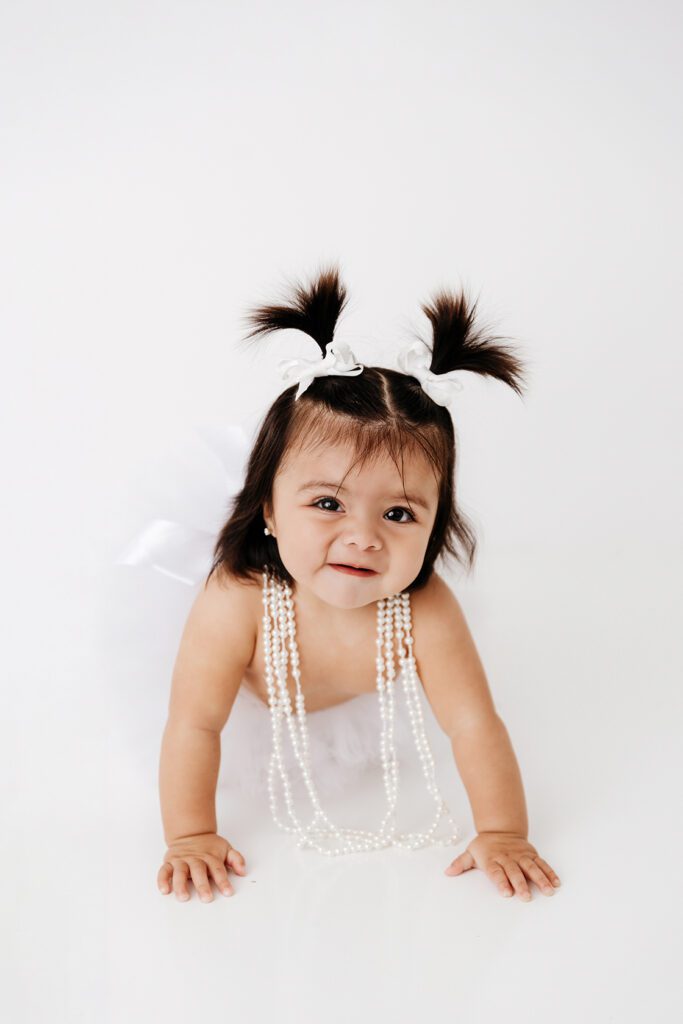 baby girl with pigtails and pearls
